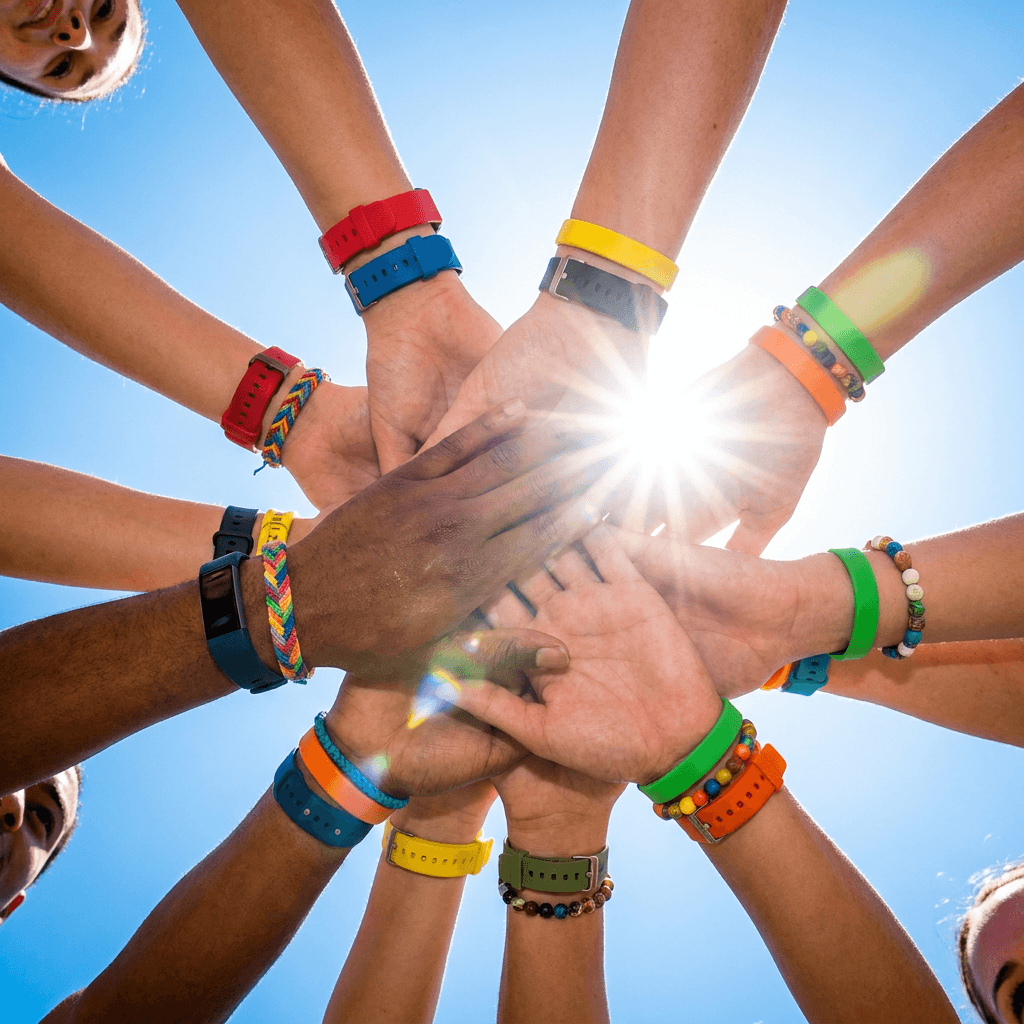 Diverse hands coming together in a team huddle showing unity